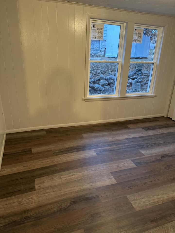 Waterproof LVP flooring installation showing seamless plank alignment in bedroom.
